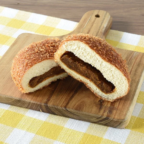 ファミマ・ザ・カレーパン。表面にザラメをトッピングし、カレーフィリングを包んだ断面。