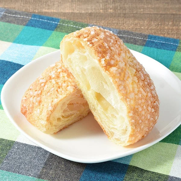 バタークロワッサンメロンパン。ザラメトッピングの表面と層状の断面が写る。