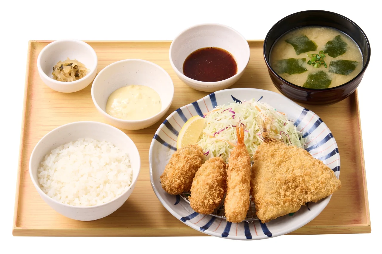 ~濃厚な海の恵み~かきフライミックス定食。かきフライ、エビフライ、アジフライ、ご飯、味噌汁、小鉢が並ぶ。