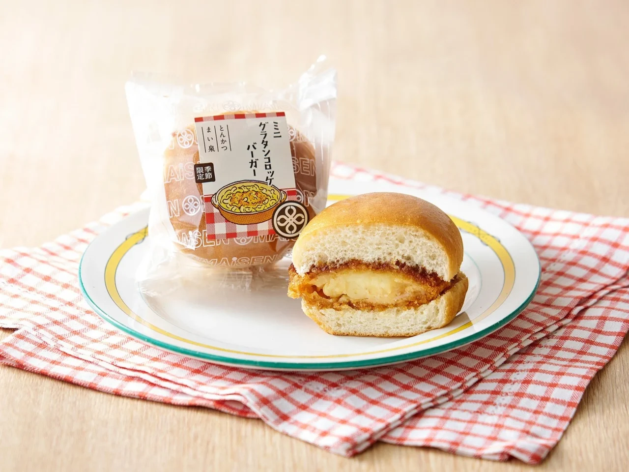 ミニグラタンコロッケバーガーの包装と、断面が見えるカットされたバーガー