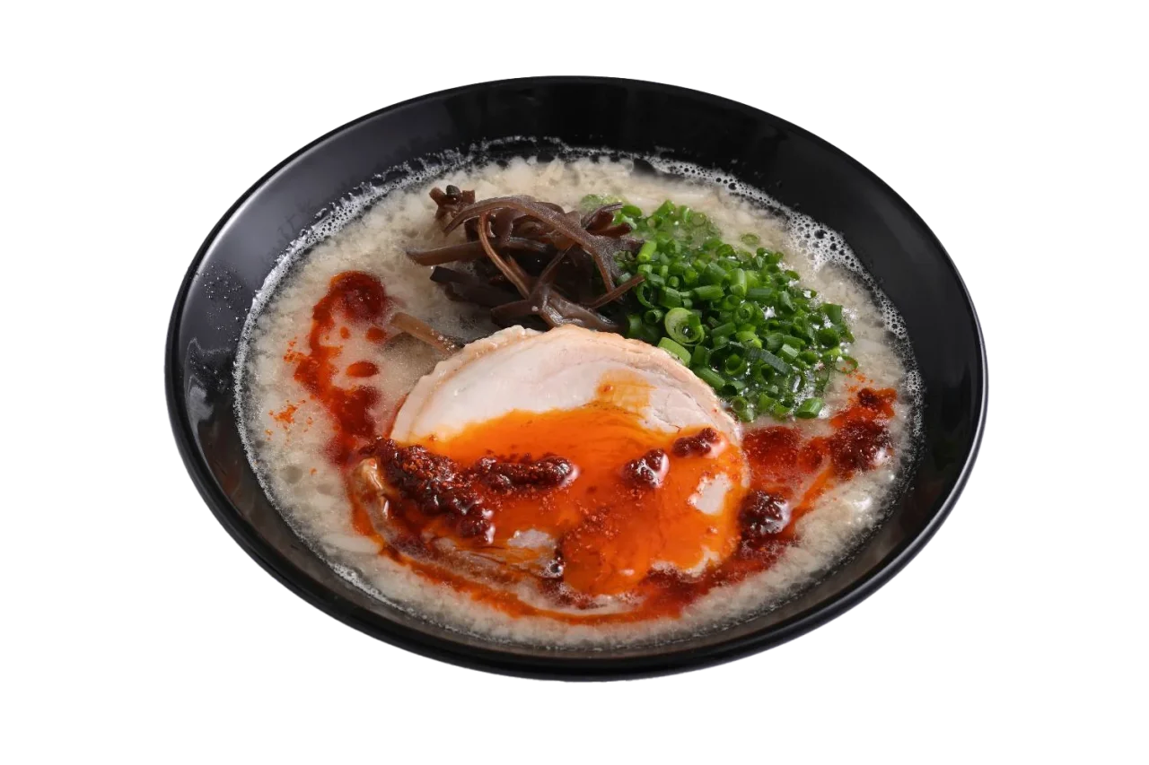旨辛豚骨ラーメン。黒い丼に白濁スープ、赤い辛味油、チャーシュー、ネギ、もやし。