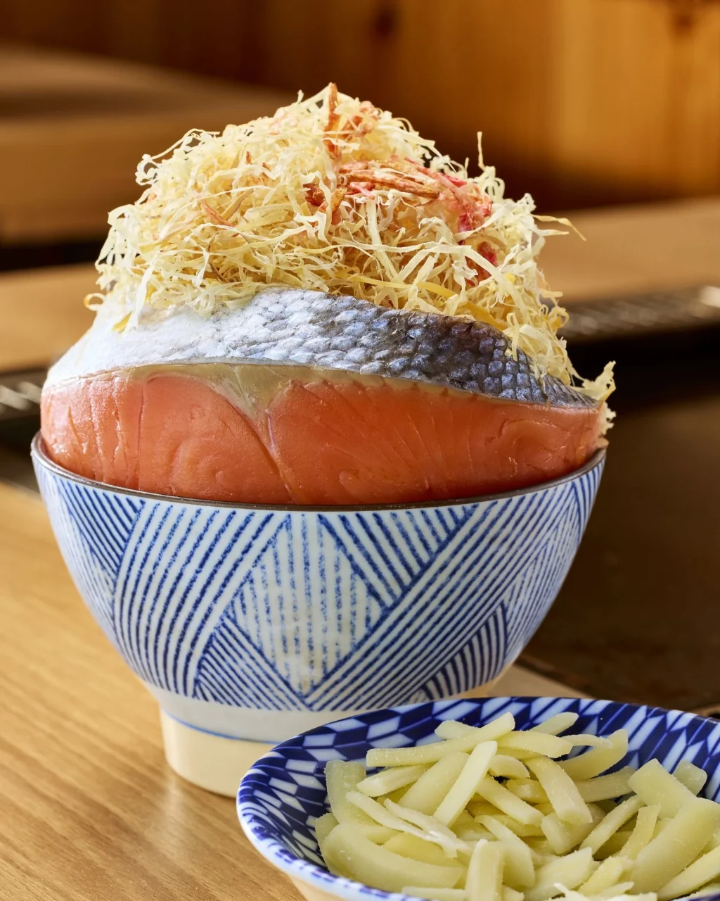 青白縞の丼に盛られた鮭の刺身と、細切りの生姜