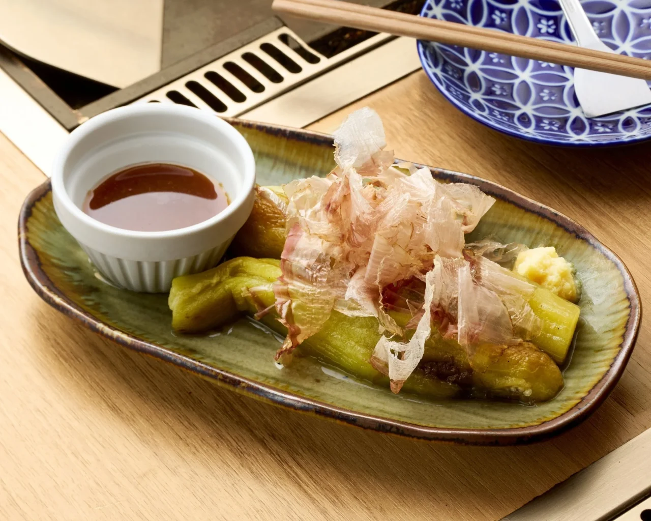 焼き茄子に削り節を乗せ、ポン酢を添えた鉄板焼き・おつまみ