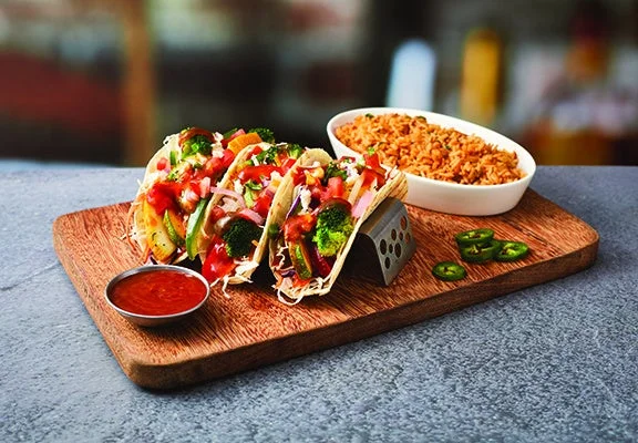 VEGGIE TACO MIX ベジータコミックス。野菜をトッピングしたタコスとスパニッシュライスの提供例。