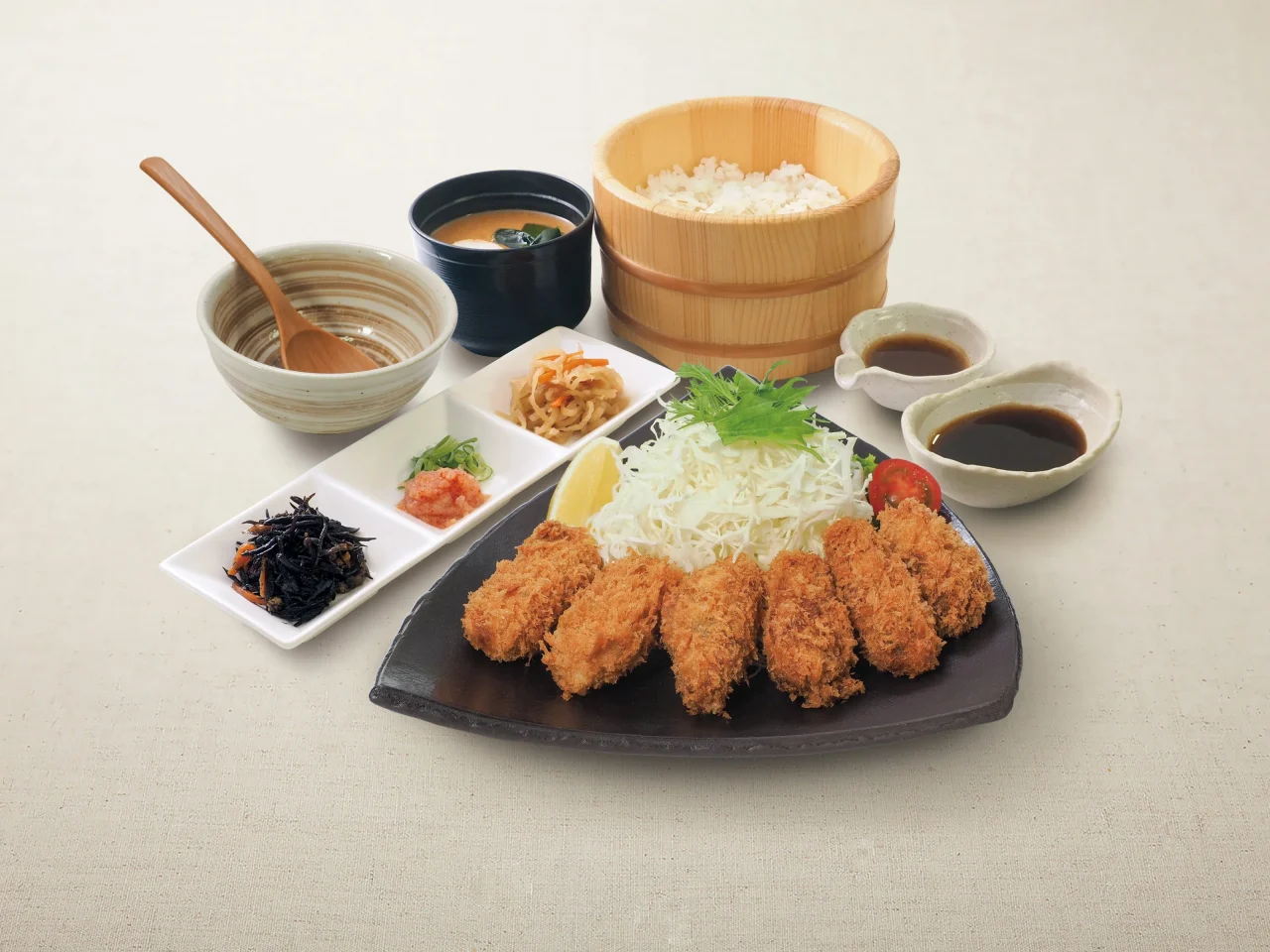 選べるソースで食べるひとくち牡蠣フライ御膳。牡蠣フライ、おひつ、薬味、ソースが並ぶ