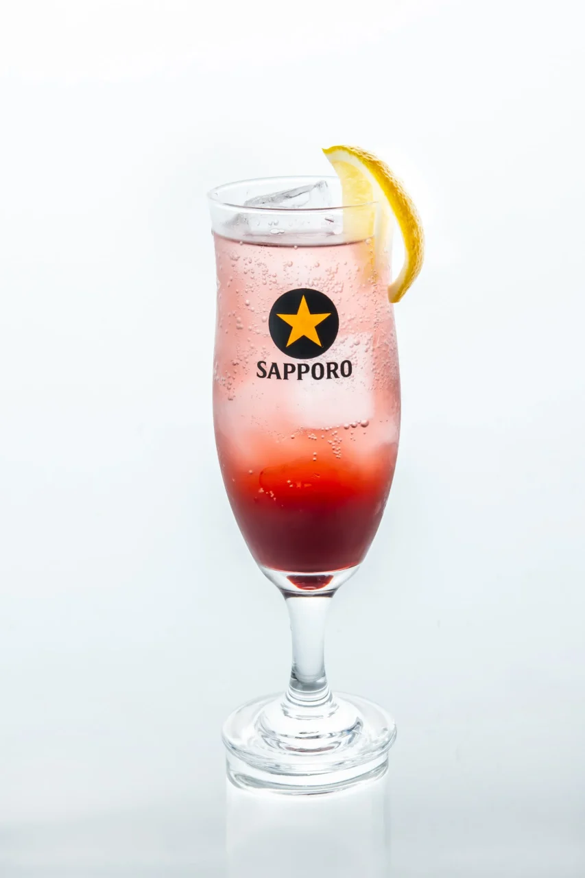 SAPPOROロゴ入りのグラスに注がれたルビー色のカシスハイボール