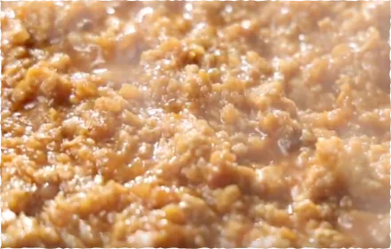 肉辛まぜうどんの具材「特製ミンチ」のアップ。香辛料を効かせた褐色のひき肉が煮込まれた状態。