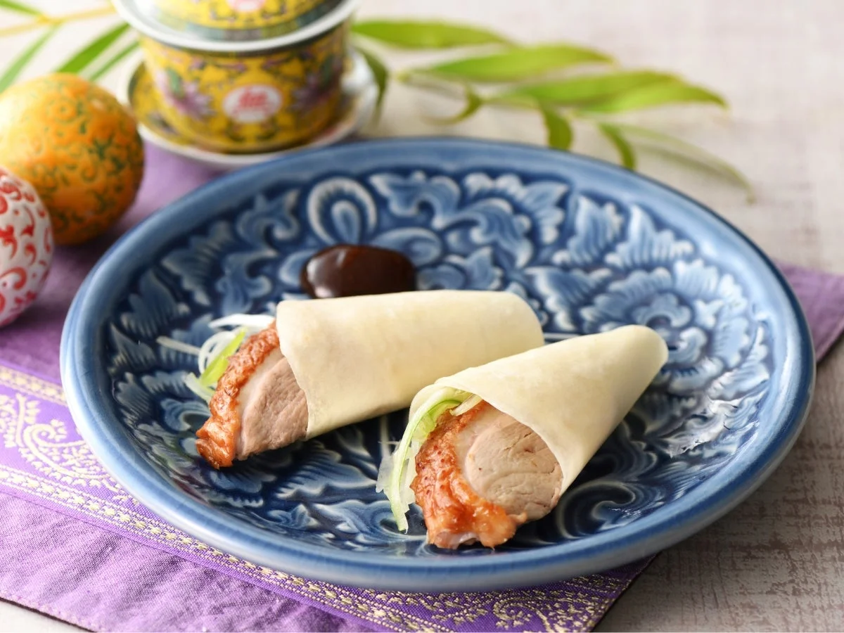 北京ダックをパオピンで巻いた料理が青い皿に盛られている