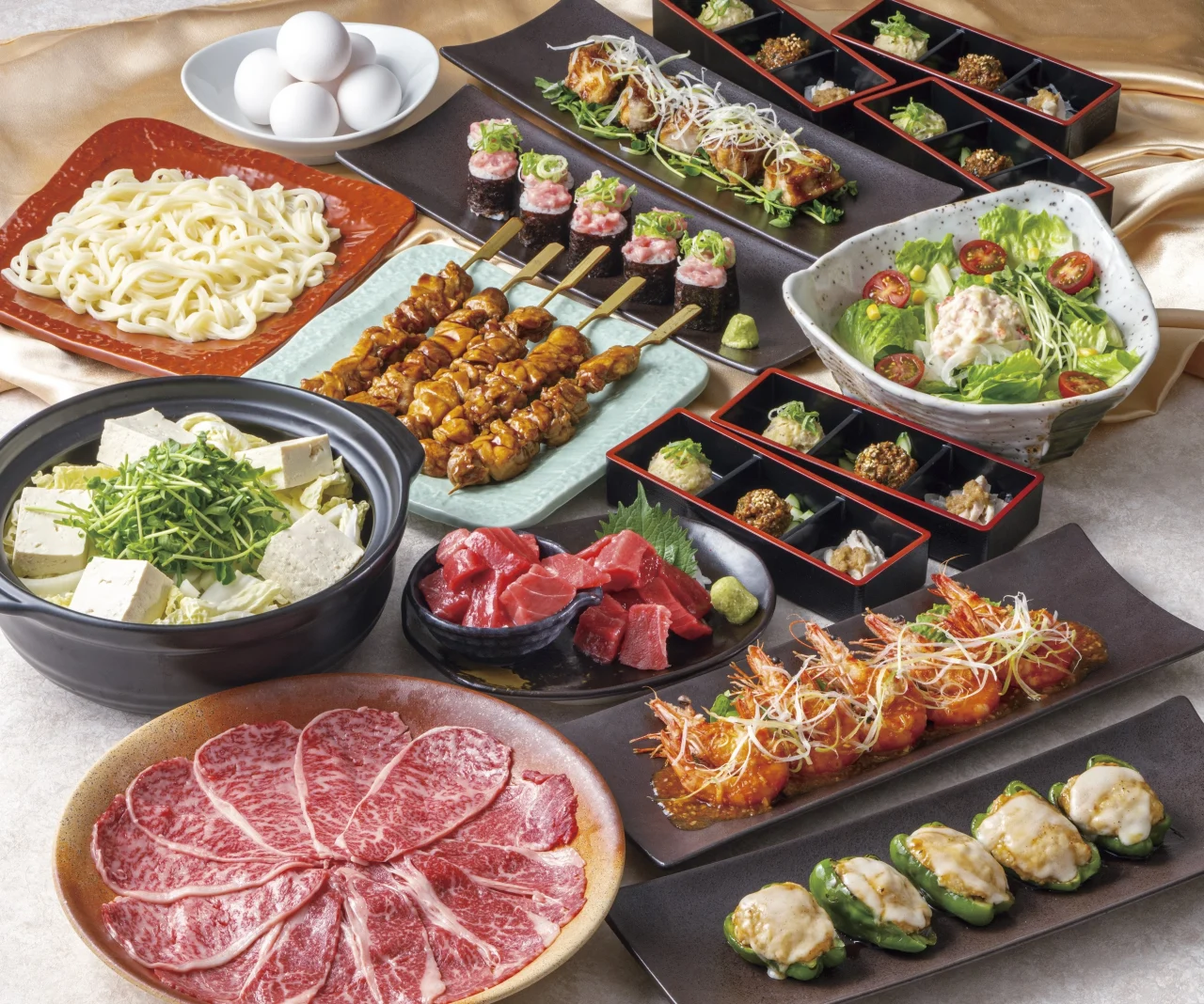 祝コースの料理一式。黒毛和牛のすき焼き、本マグロの天盛り、清流若どりもも一本串などが並ぶ。