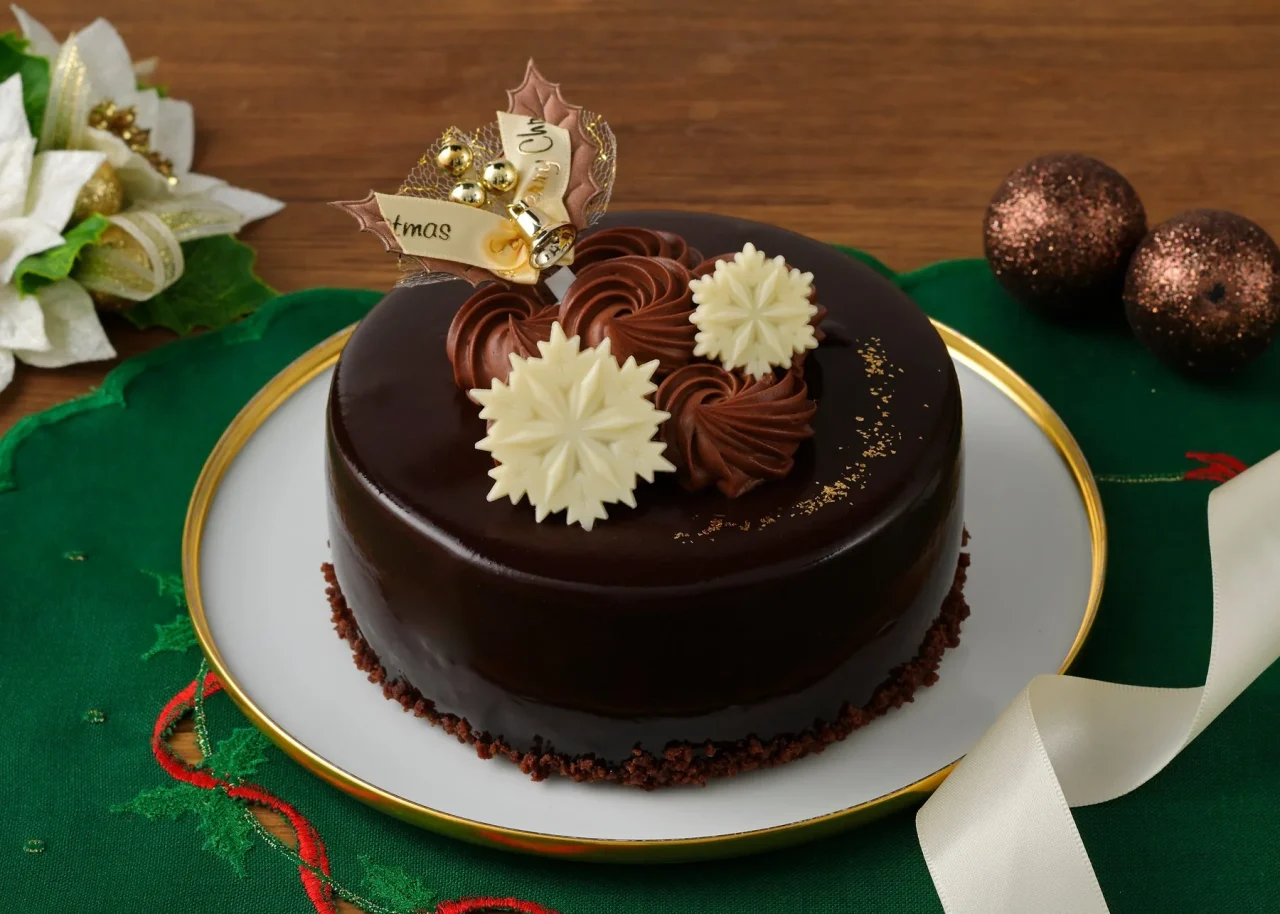 ミロワールショコラの艶やかなチョコケーキ。雪の結晶チョコとリボンが飾られている。