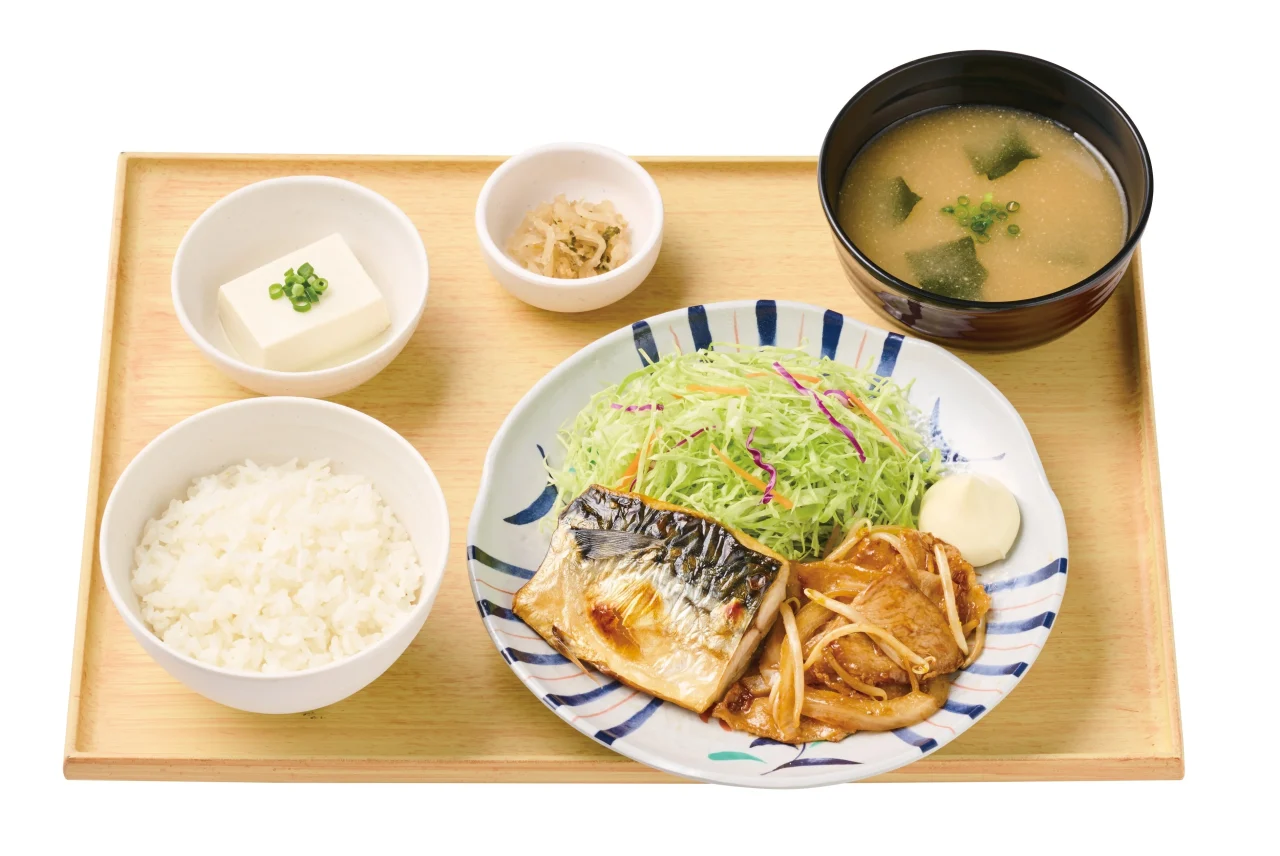 サバの塩焼としょうが焼の定食。ご飯、汁物、小鉢とともに盆に並ぶ