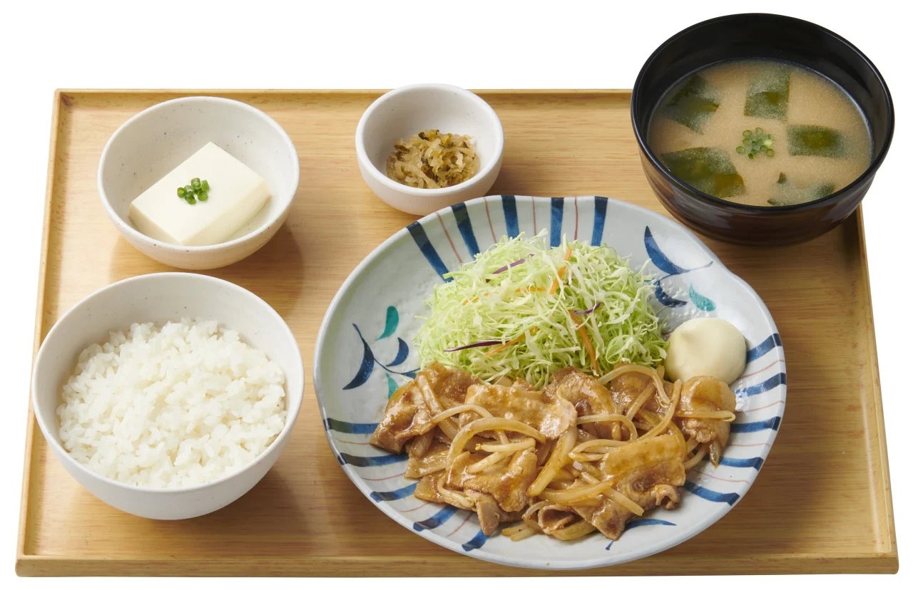 しょうが焼定食。しょうが焼と千切り野菜、ご飯、みそ汁、小鉢が並ぶ