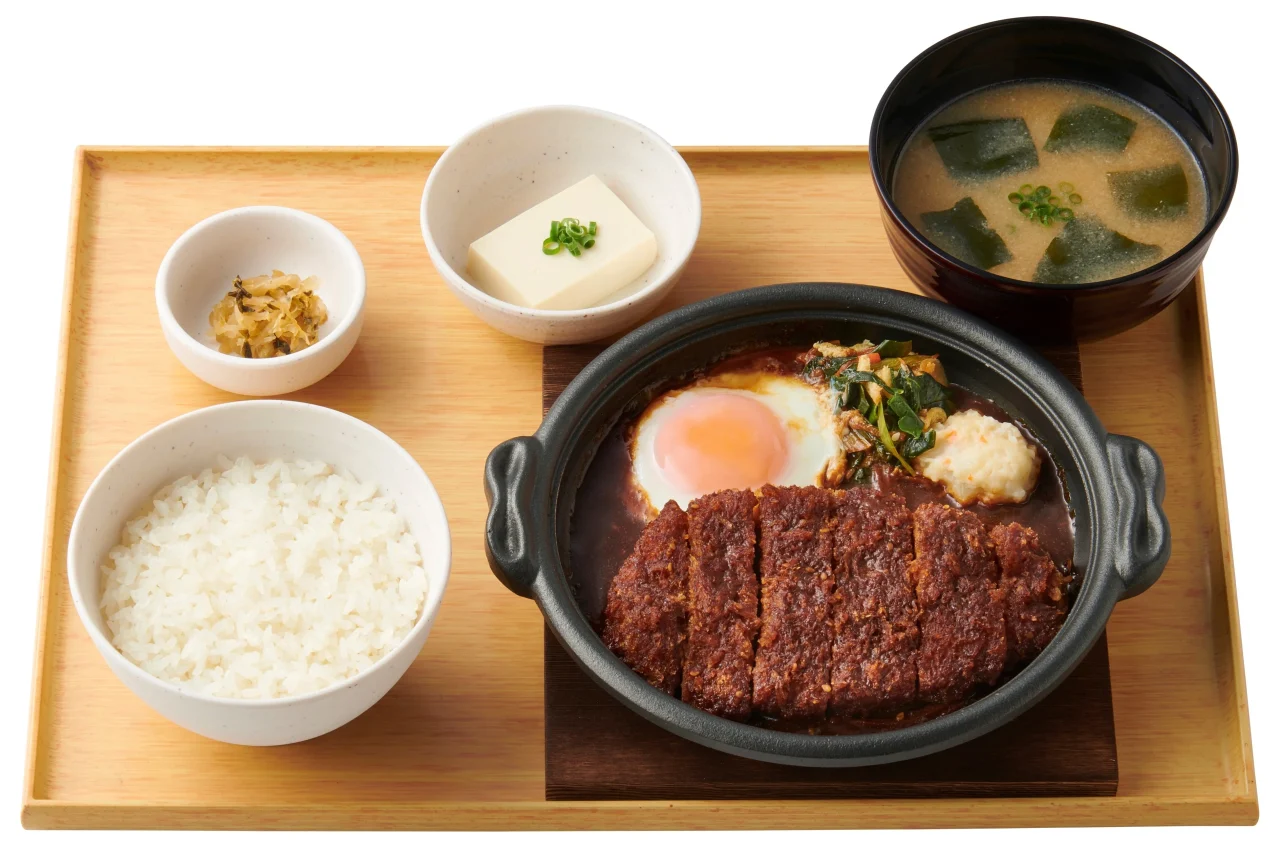 味噌かつ煮定食。鍋のかつと卵、ご飯、汁物、小鉢が木盆に並ぶ