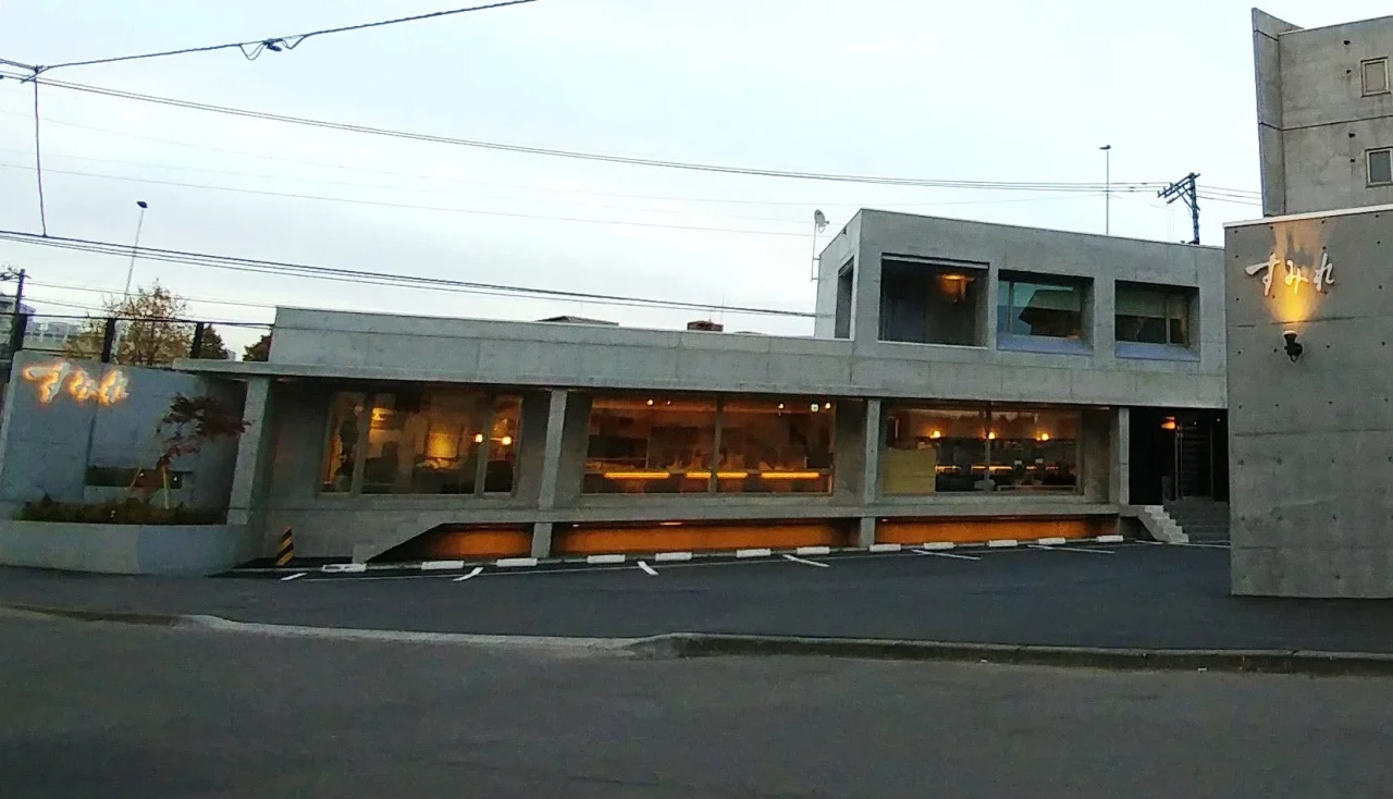 すみれ本店の外観。横長の窓が並ぶコンクリート調の建物
