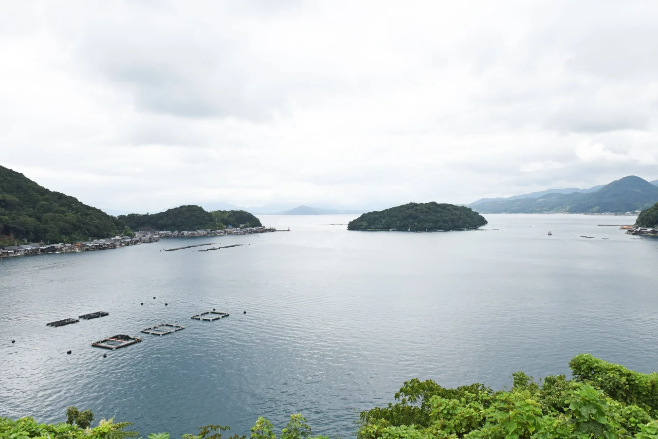 山と島に囲まれ、海上に養殖いかだが浮かぶ伊根湾