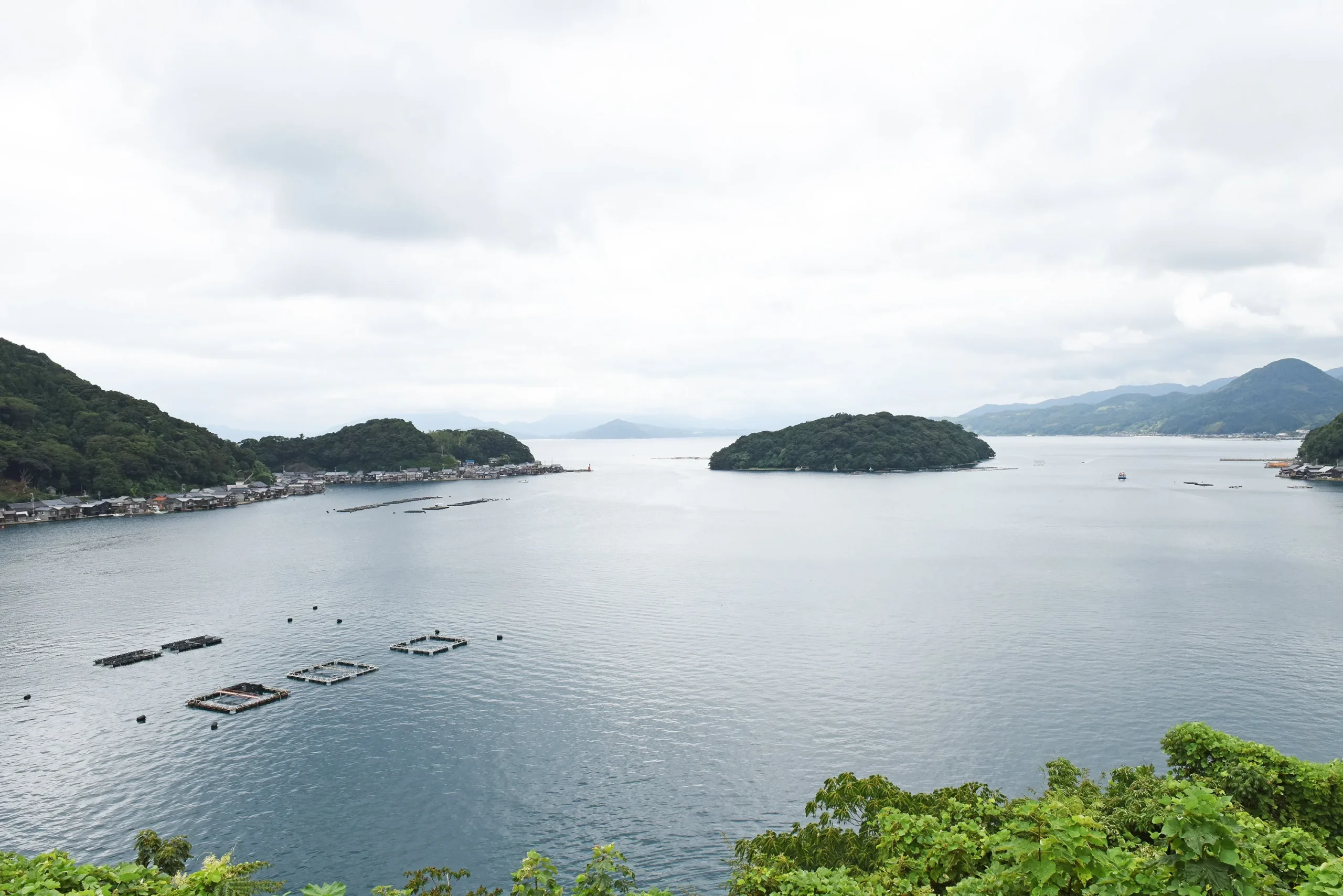 山と島に囲まれ、海上に養殖いかだが浮かぶ伊根湾