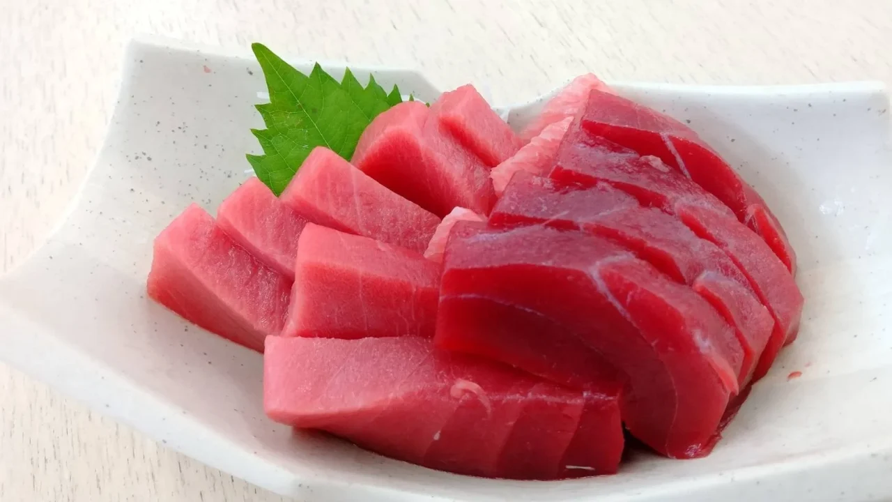 白い皿に盛られた京まぐろのお造りと緑の葉