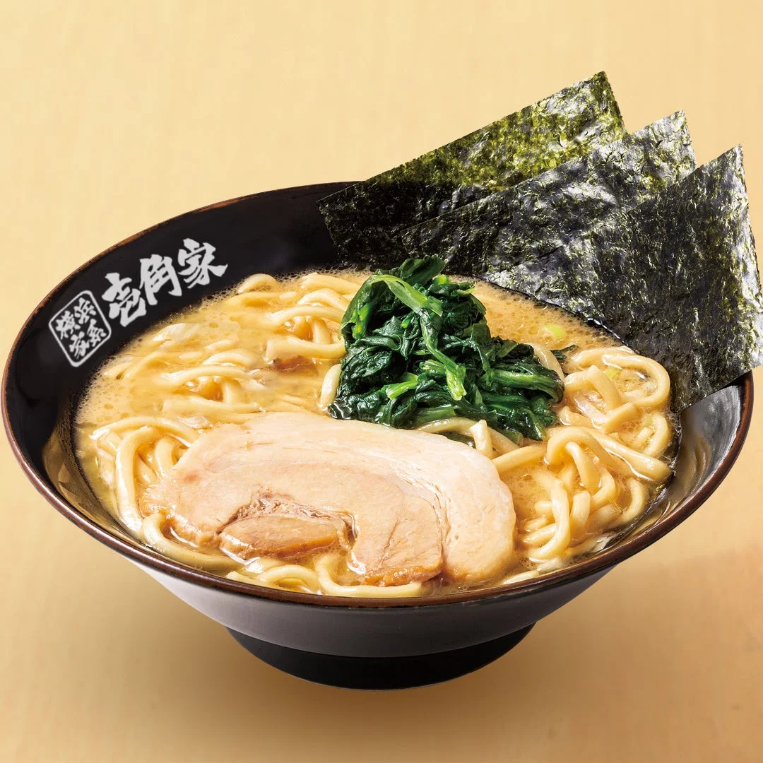 壱角家の家系ラーメン。黒い丼に豚骨スープ、中太麺、チャーシュー、青菜、海苔が入っている。