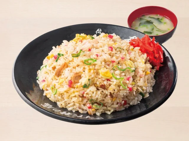 黒い皿に盛られたチャーハンと、赤い器に入ったスープ