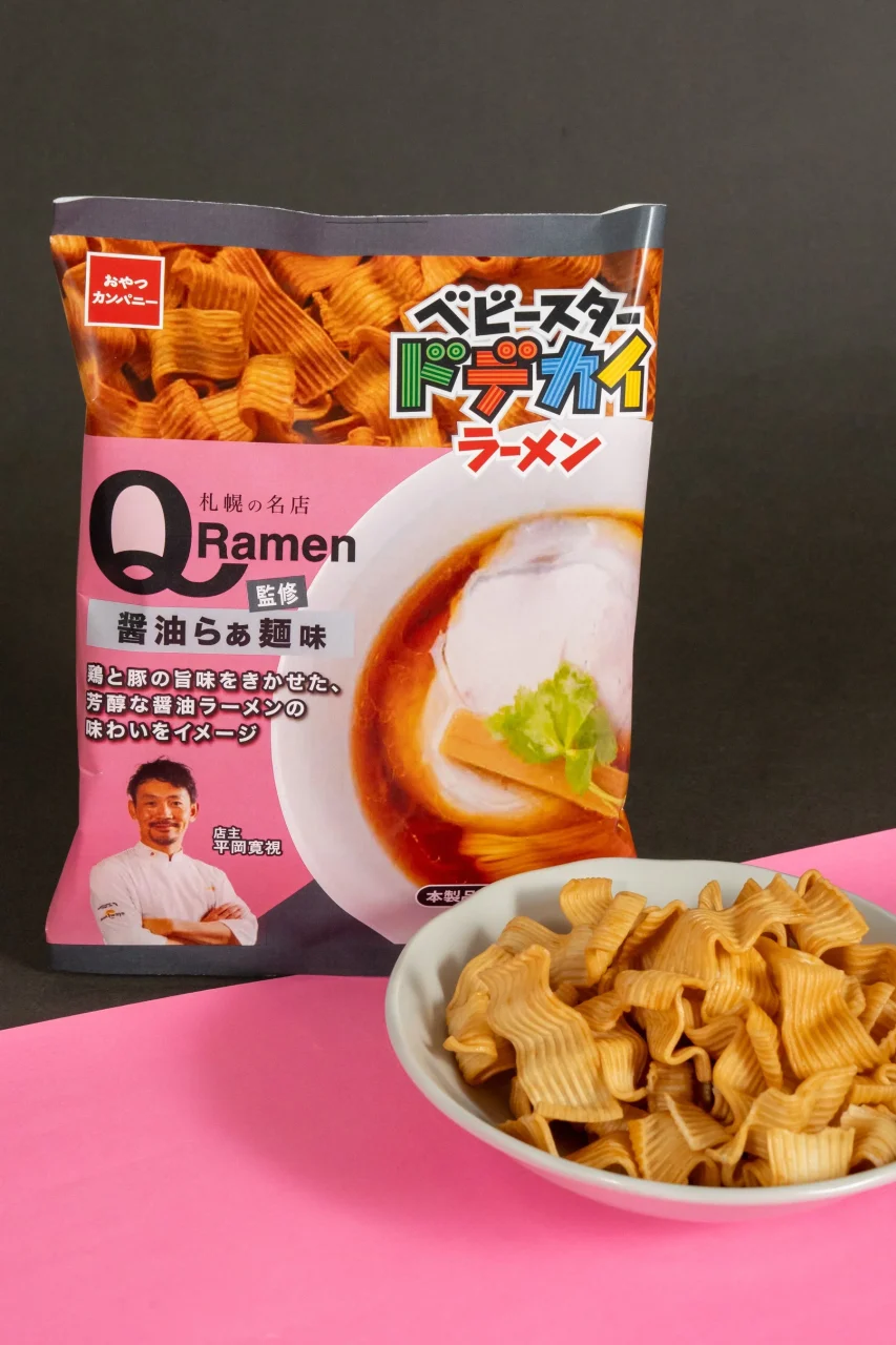 ベビースタードデカイラーメンQ監修醤油らぁ麺味の袋と、皿に盛られた波型の麺菓子
