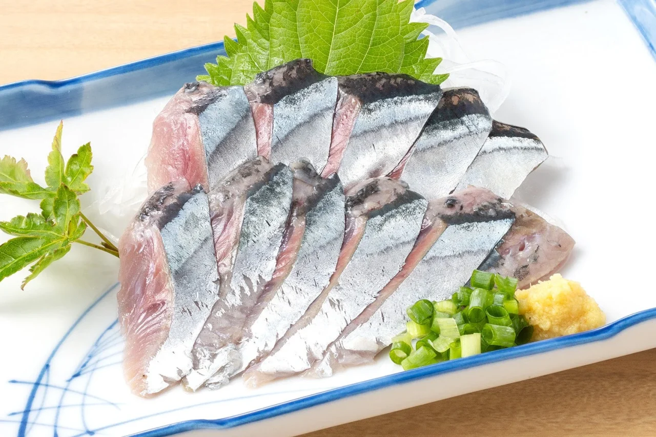 生さんま 刺身。銀鱗のさんまを薄く切り、紫蘇やネギ、山葵を添えて盛り付けた刺身。