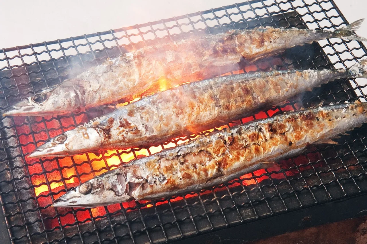炭火で焼かれたさんまの塩焼きが3匹並んでいる