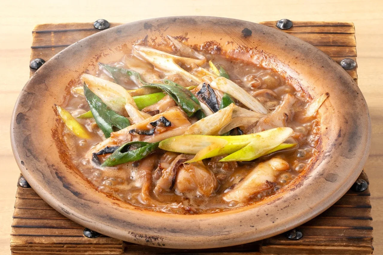 陶板の上でニンニクやネギと共に焼かれた烏賊ゴロ 陶板焼き