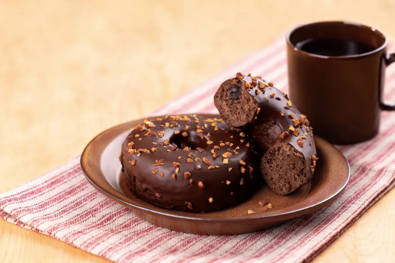チョココーティングとナッツを散らしたリングドーナツとコーヒー