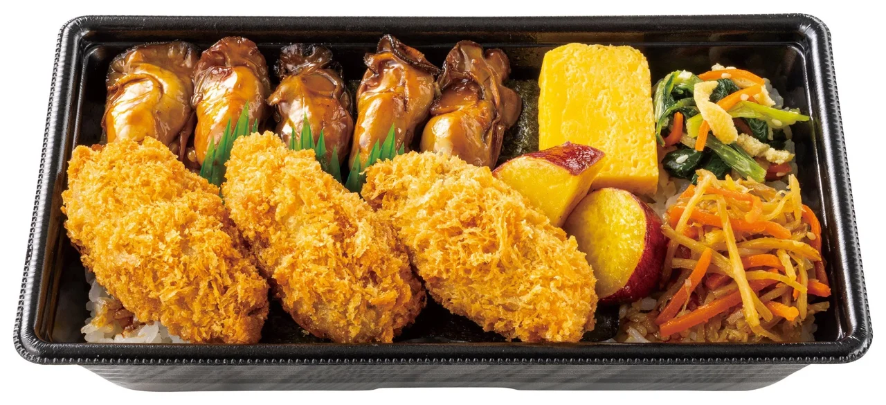カキフライと茹で牡蠣、卵焼き、野菜炒め、果物が入った黒い弁当箱