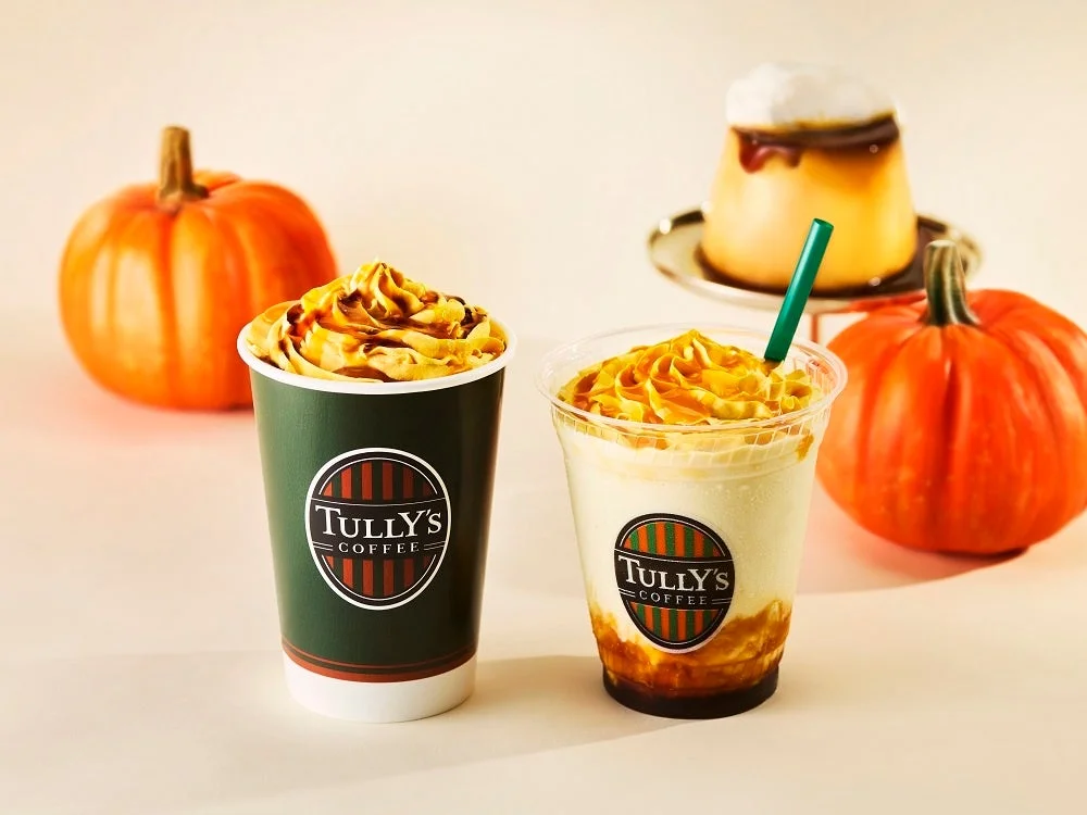 ホイップとソースをのせた2杯のドリンクと、背景のかぼちゃ