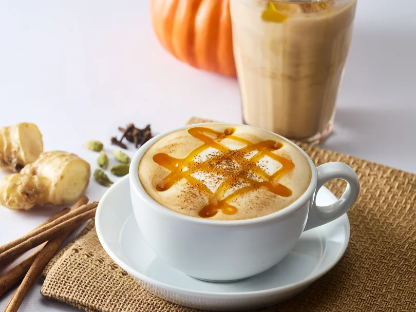 &TEA パンプキンチャイミルクティー、白いカップと奥の冷たいドリンク