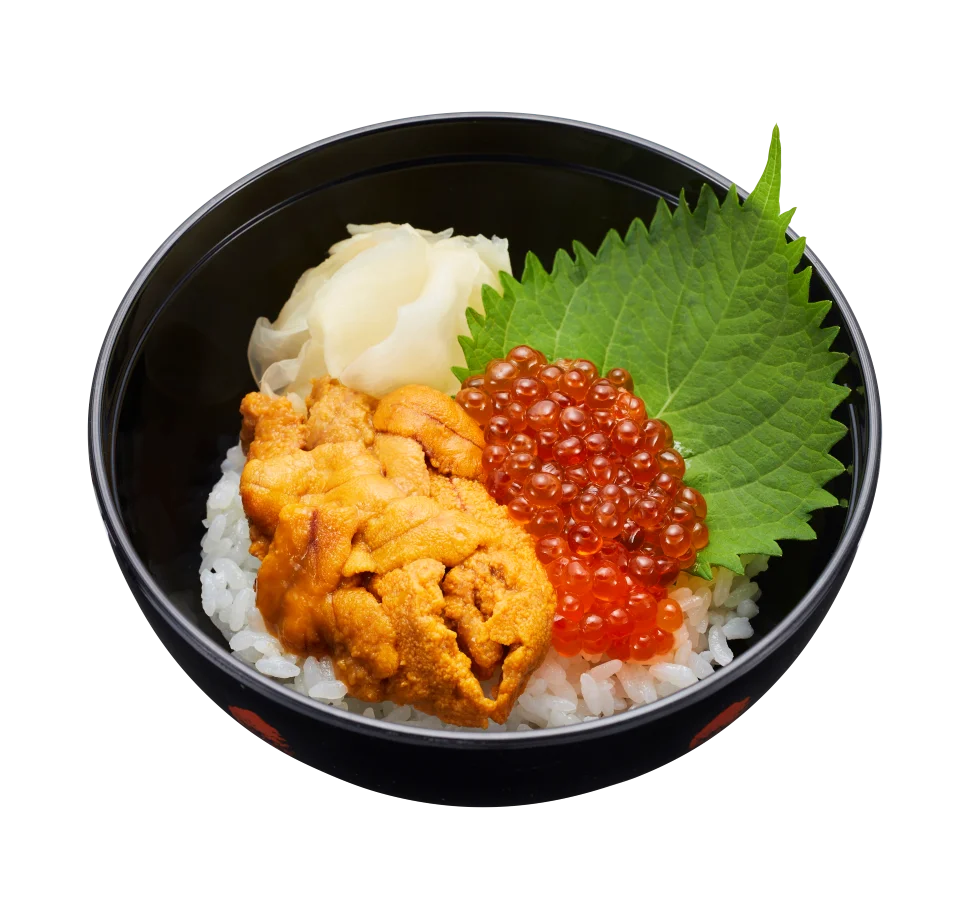 黒い器のご飯に橙色の具と赤い粒状の具、緑の葉を盛った小丼
