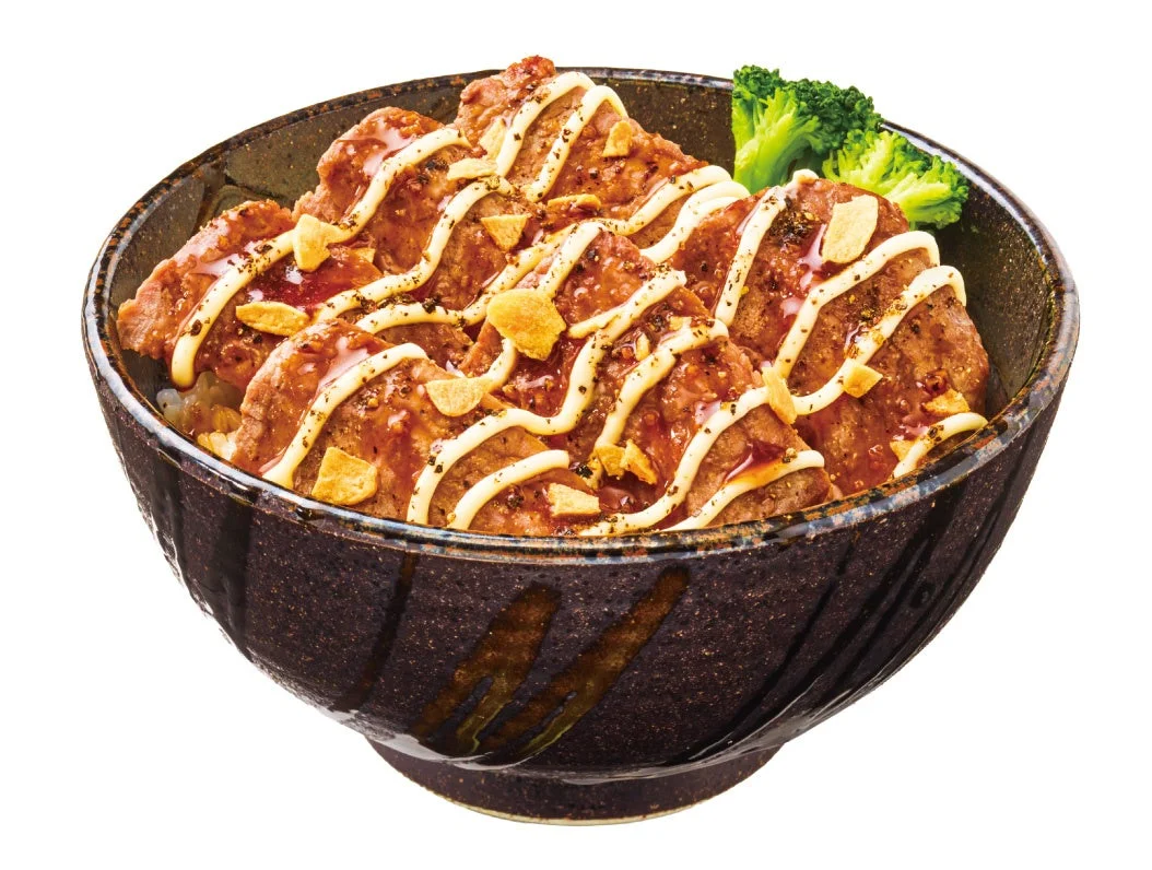 ガリマヨペッパー牛ロースステーキ丼。黒い丼に肉と波状のマヨネーズ
