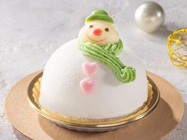 Xmasスノーマンのホワイトチョコムースケーキ。緑のマフラーと帽子の雪だるま