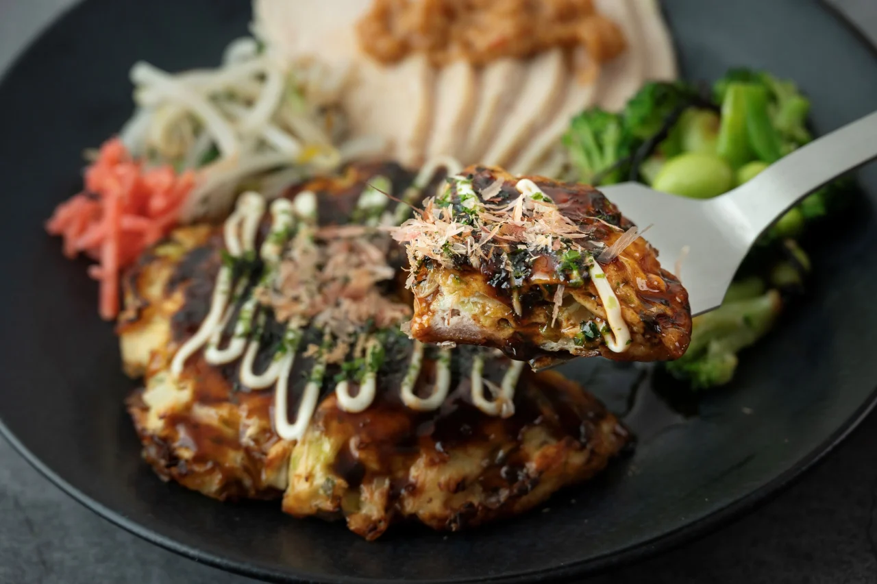 ふんわりお好み焼きと鶏の辛みそだれセット。お好み焼きをヘラで持ち上げた様子