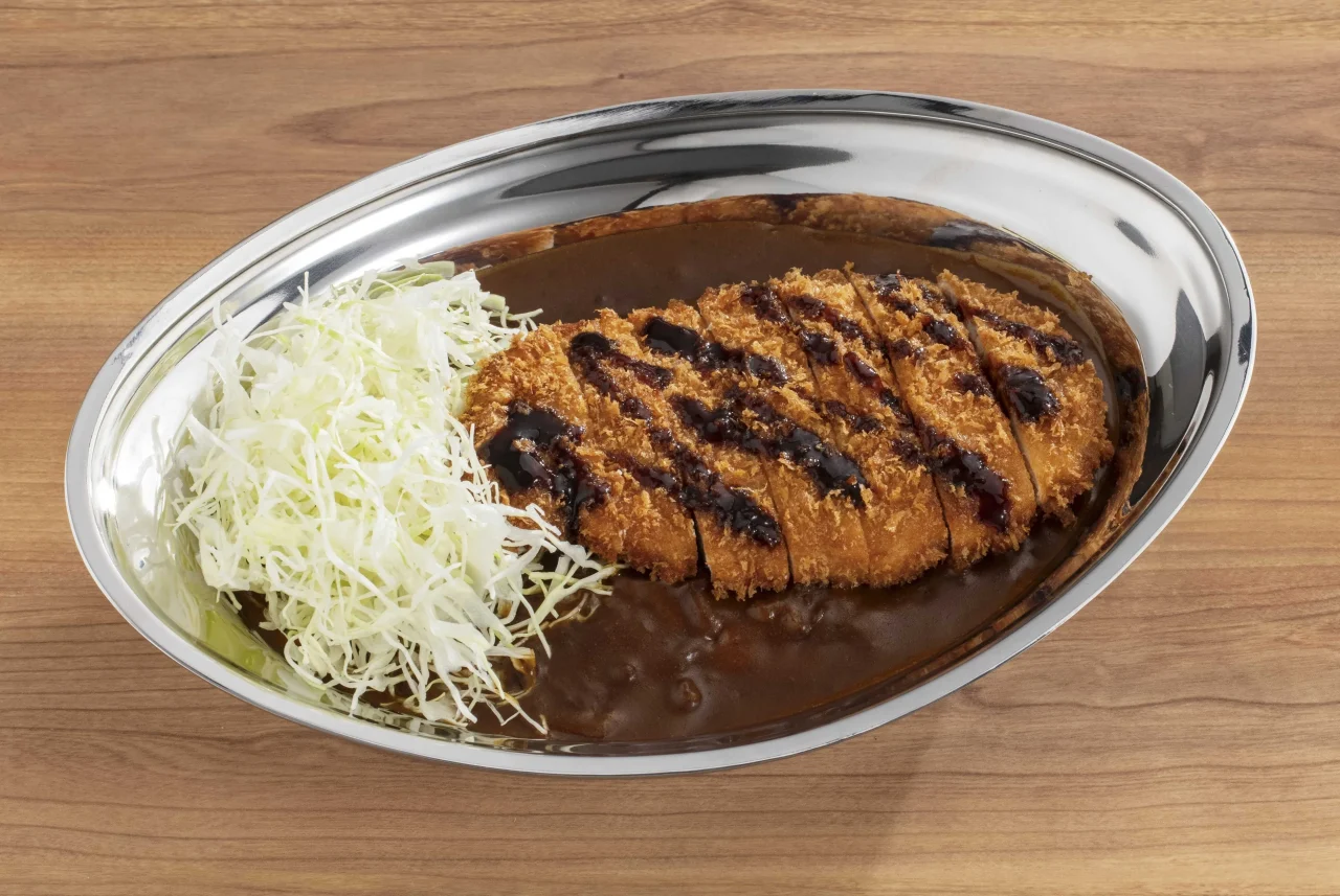 Lカツカレー。銀皿にカレーと千切りキャベツ、カットしたカツをのせた一皿