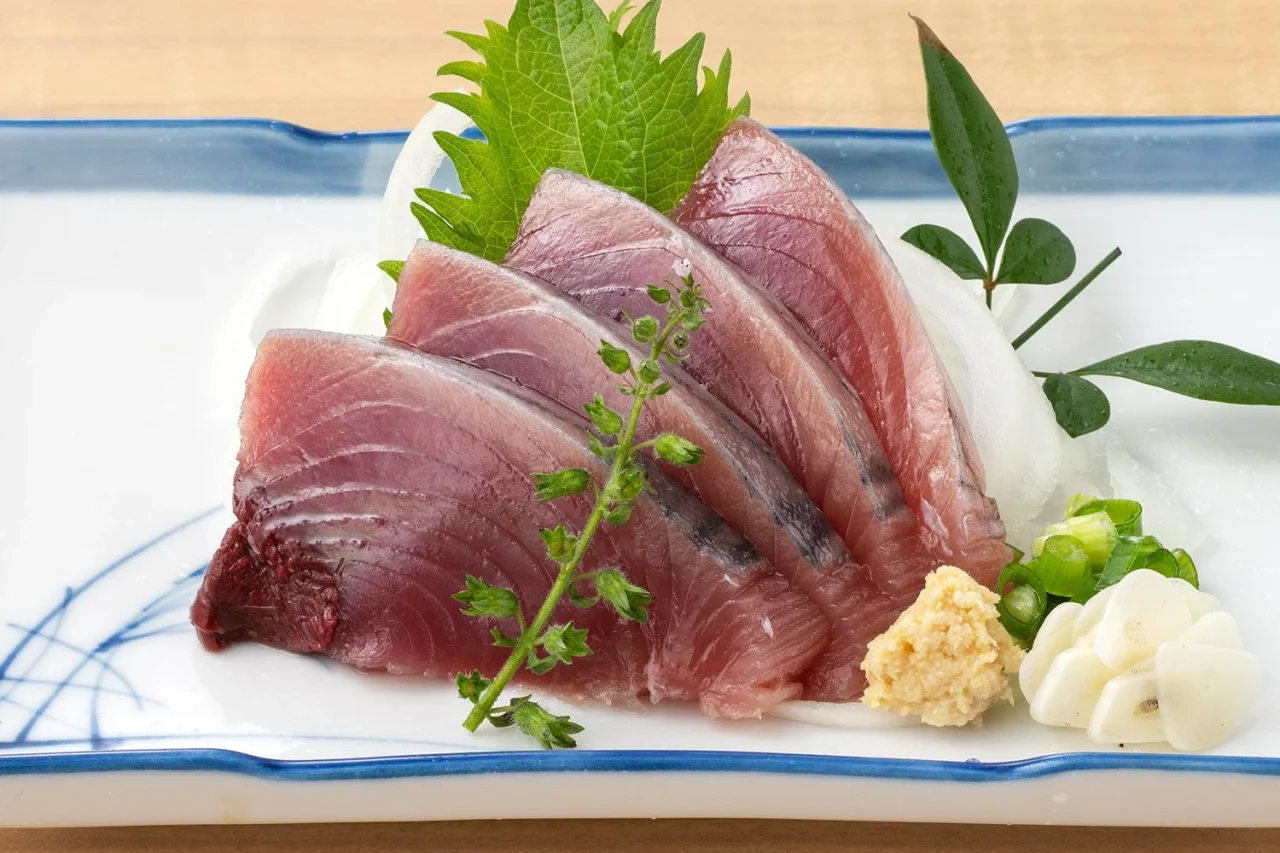 戻りかつお 刺身。大葉とわさび、薬味を添えた皿盛り