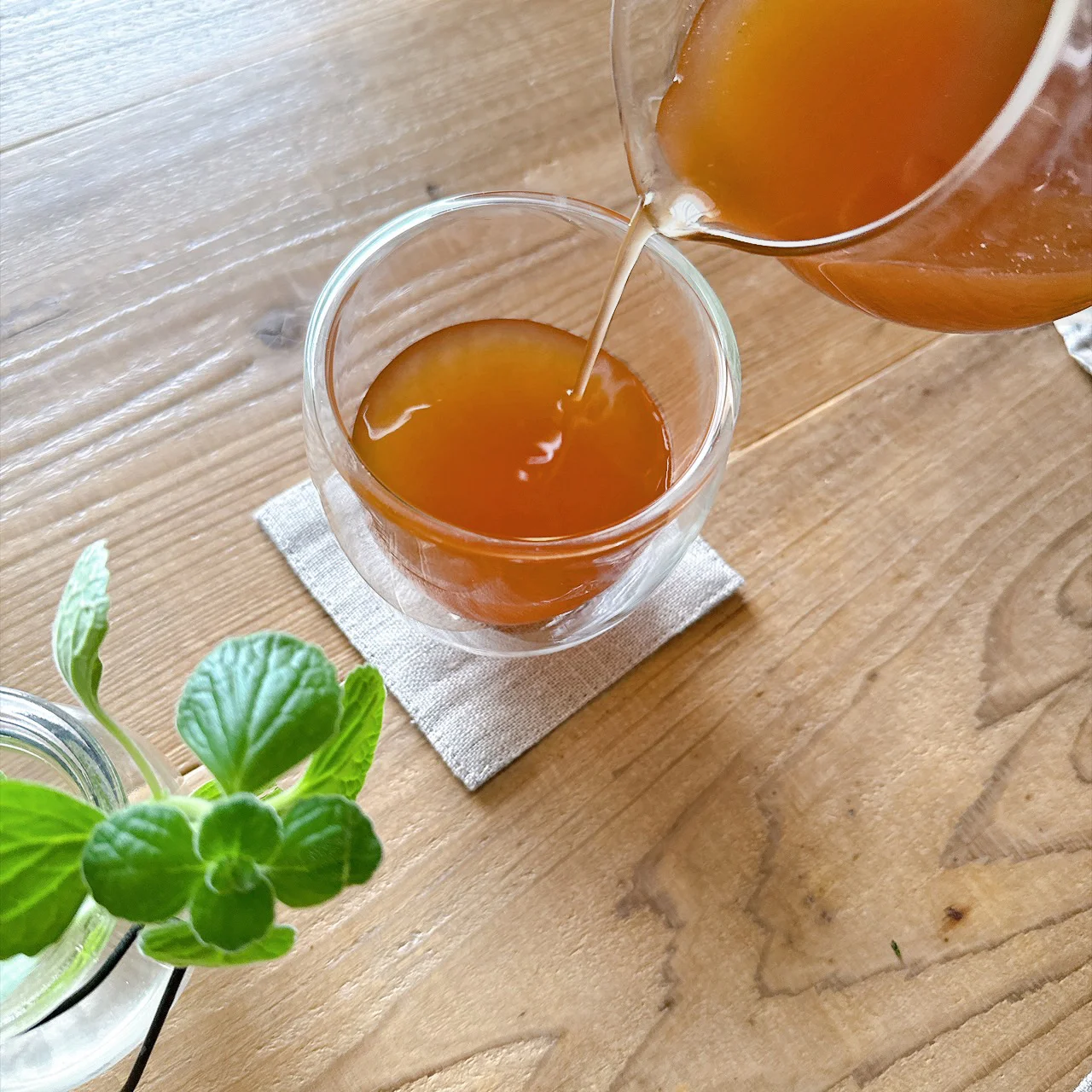 飲み方イメージ。琥珀色のお茶を透明なグラスに注ぐ様子