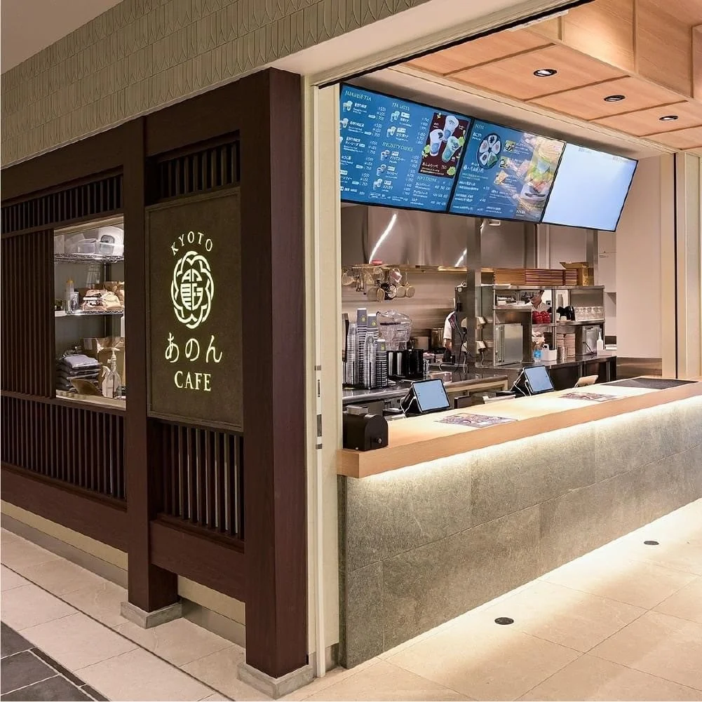 KYOTO あのん CAFEの店舗外観。木格子の壁とカウンター、メニューモニター