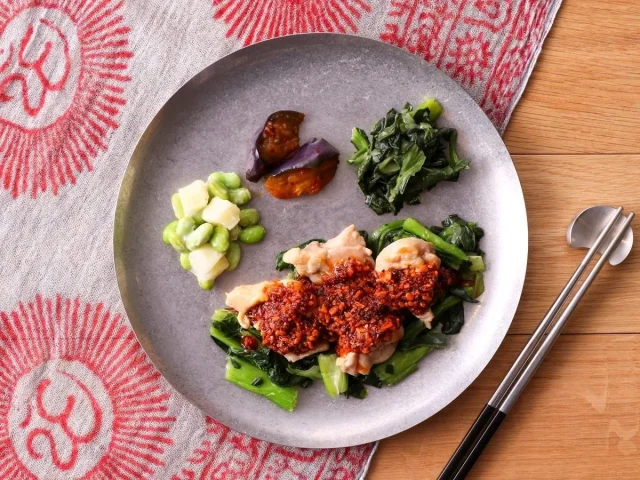 痺れる旨辛よだれ鶏と副菜を盛り付けた丸い皿