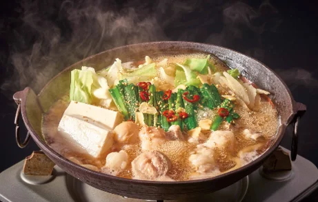 牛もつうどん鍋(醤油味)。鍋に豆腐、キャベツ、もつ、ニラ、唐辛子