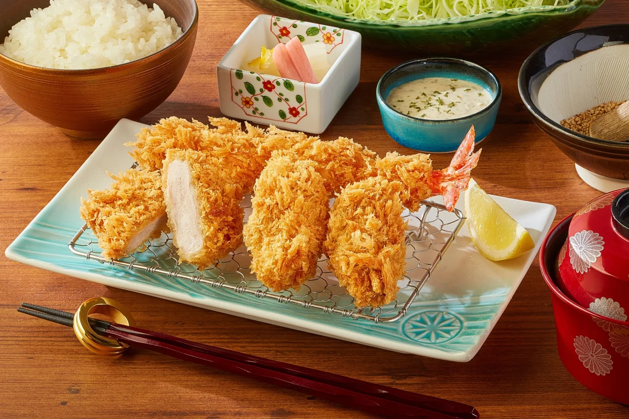 ごはんやタルタルソース、レモンが添えられた揚げ物の盛り合わせ定食