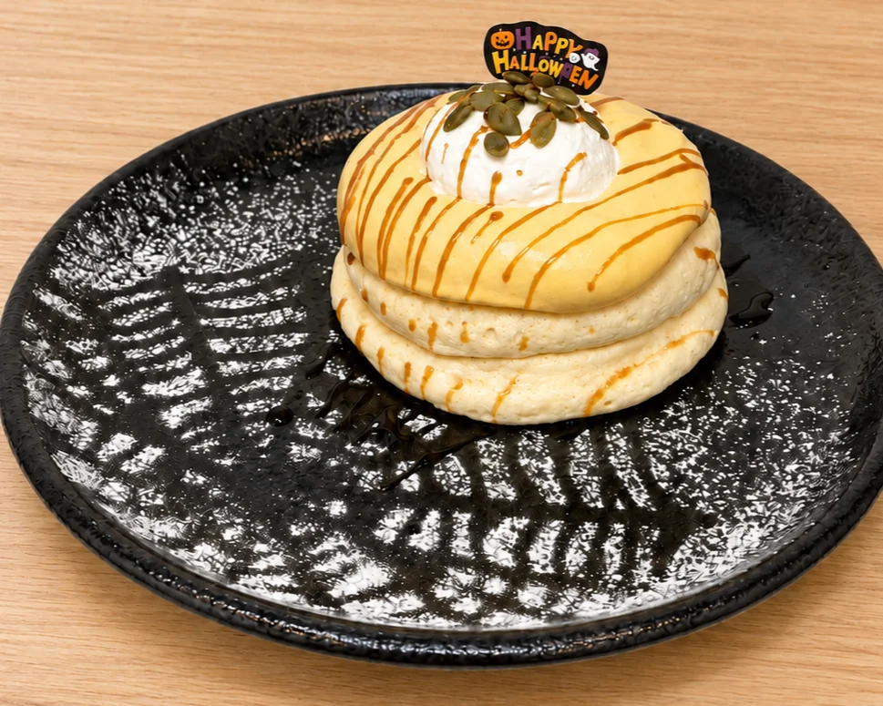 かぼちゃクリームのリコッタパンケーキ。黒い皿に重ねた生地とクリーム