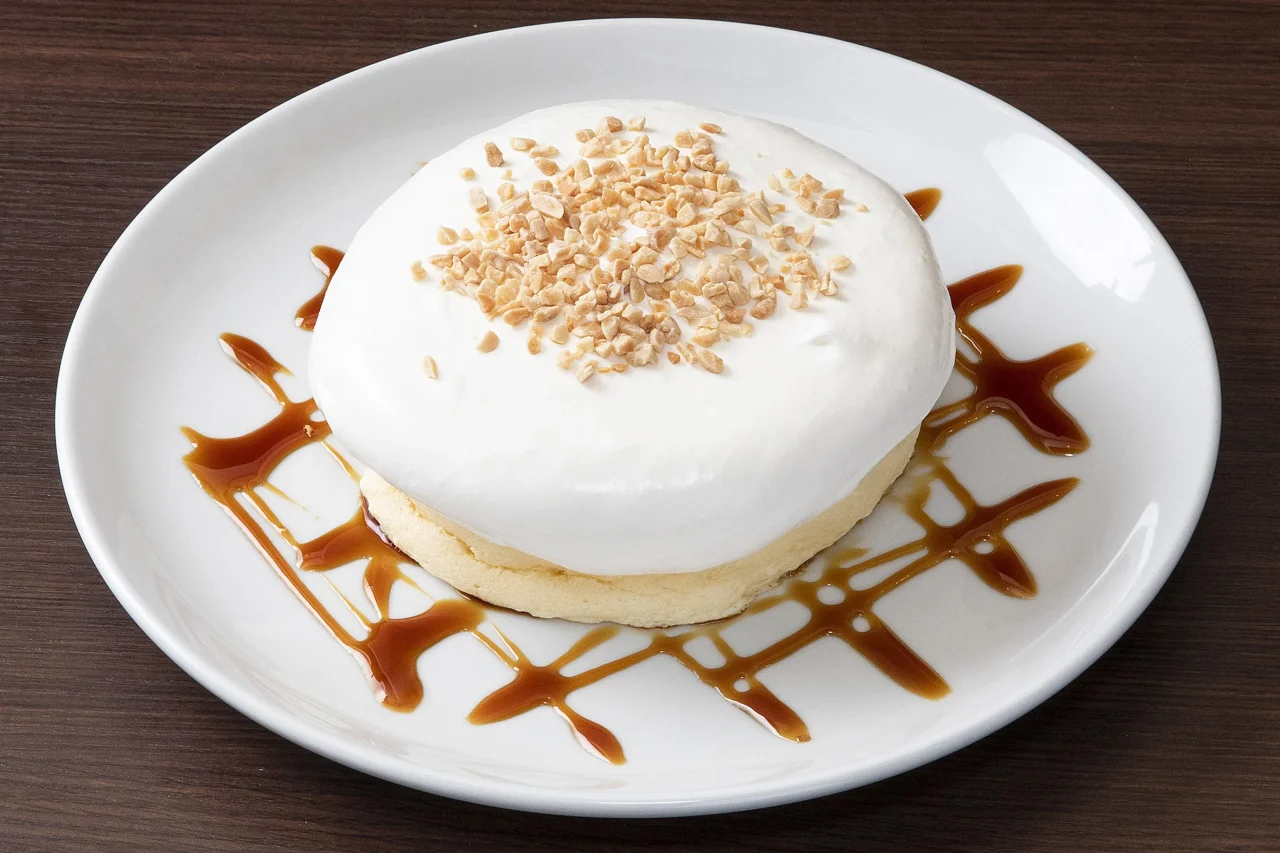 特製クリームのリコッタパンケーキ。白いクリームにナッツとキャラメルソース