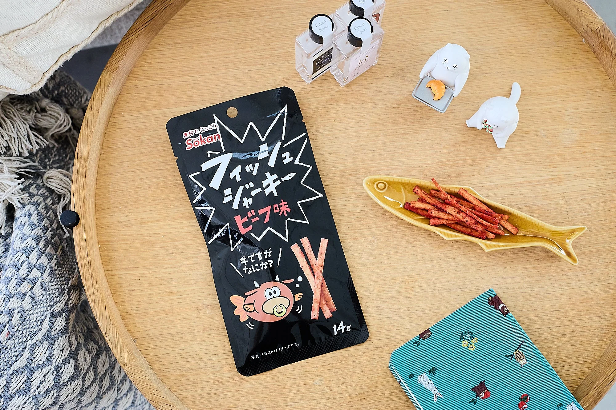 木製トレイに置かれたフィッシュジャーキー ビーフ味の黒いパッケージ