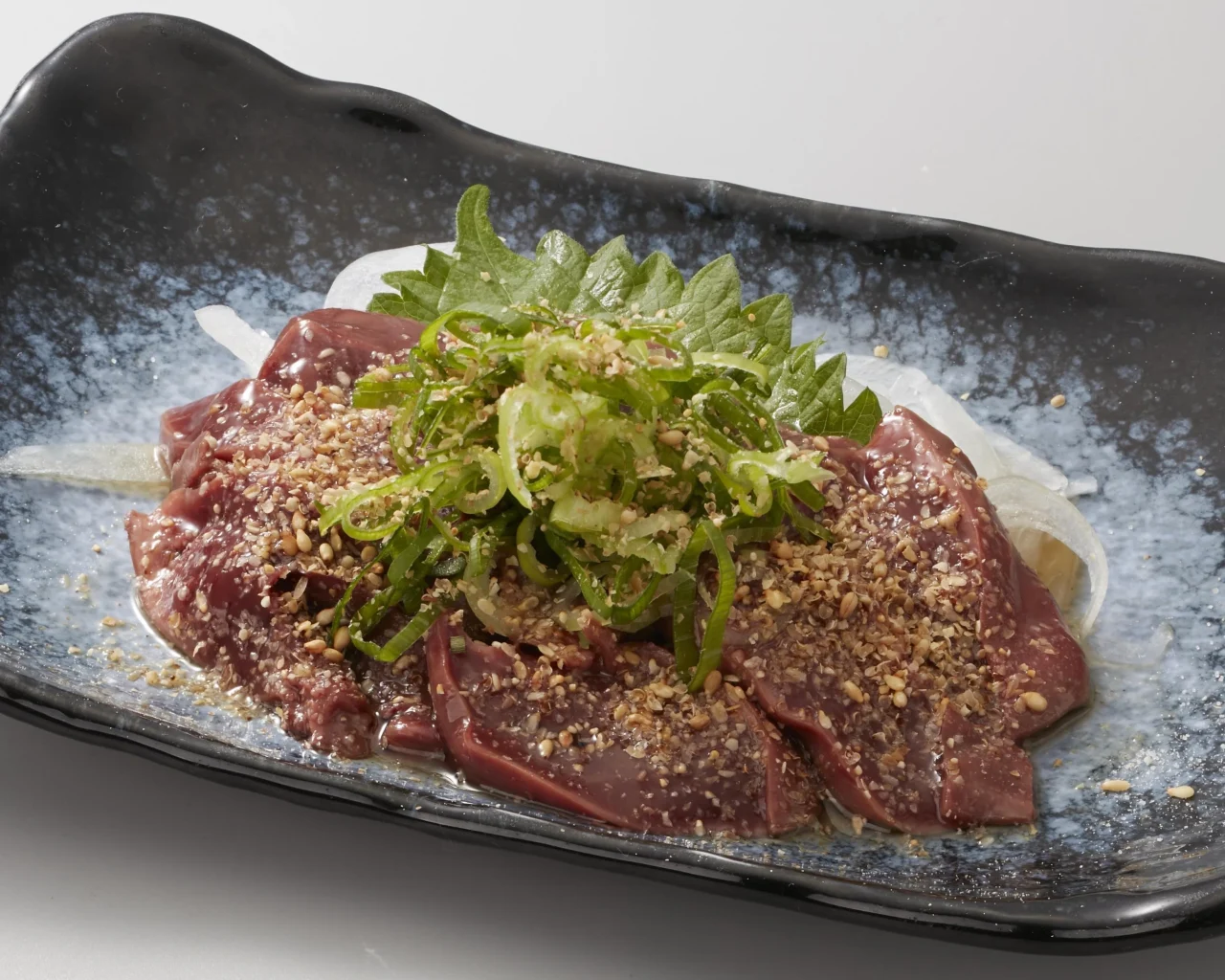 芳醇ごま！鶏レバ。ごまと大葉、ねぎをのせたスライス肝の皿