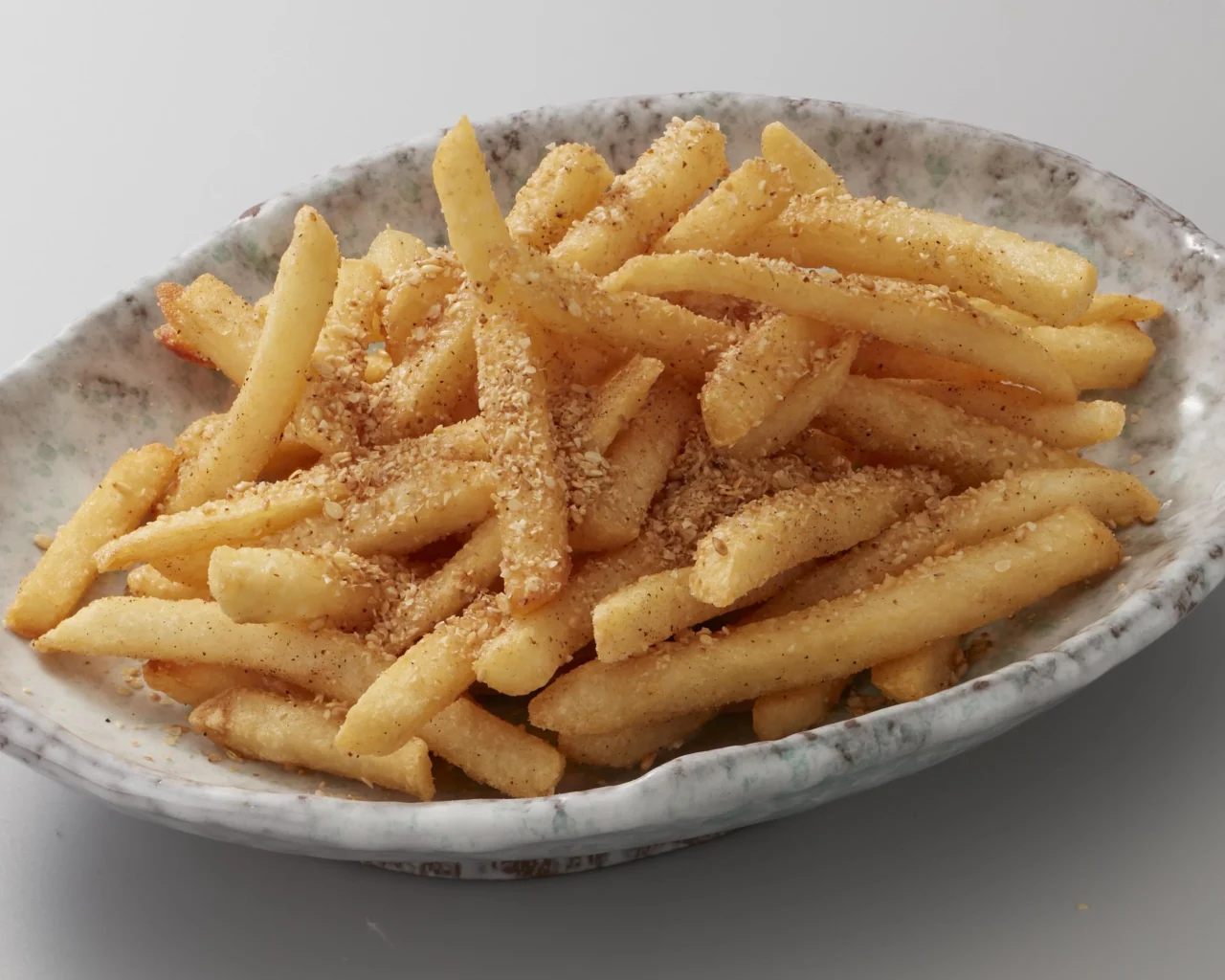 胡麻職人のポテトフライ。器に盛ったフライドポテトにすりごまをかけた一皿