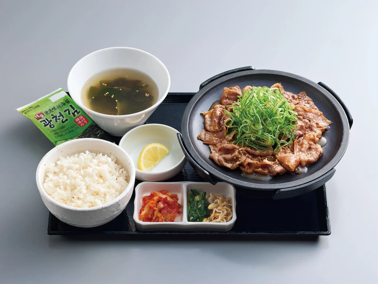 京都産九条ねぎ旨塩牛カルビ定食。鉄板のカルビにねぎ、ごはん、スープ、レモン、副菜