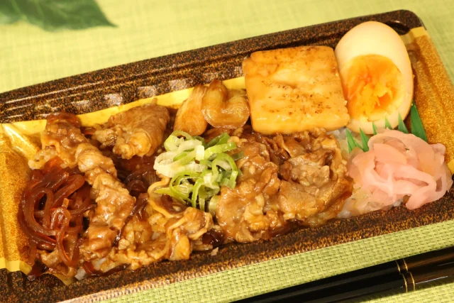 牛すき焼き重。牛バラ肉、焼き豆腐、煮卵、ねぎ、紅生姜が入った容器