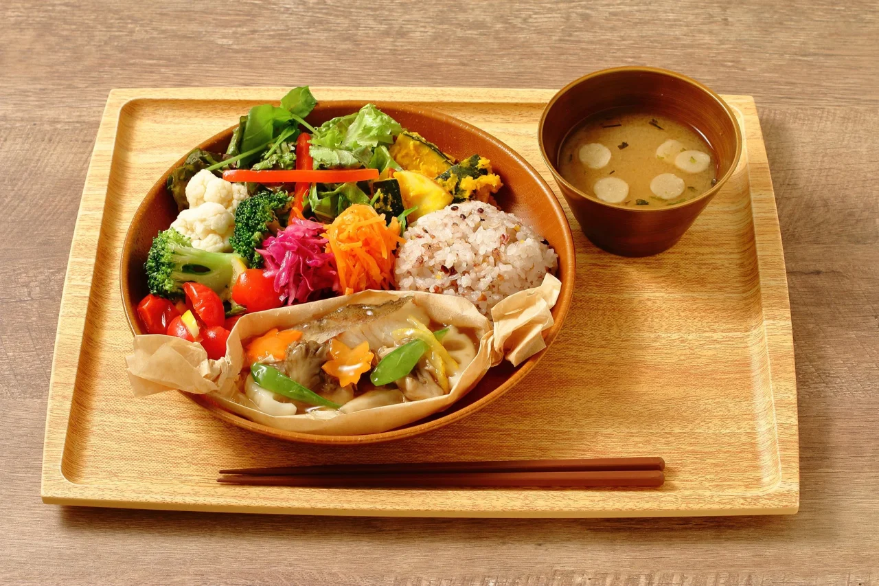 鱈と秋野菜のあんかけ定食。野菜と雑穀ご飯、あんかけ、汁物が木製トレイに並ぶ